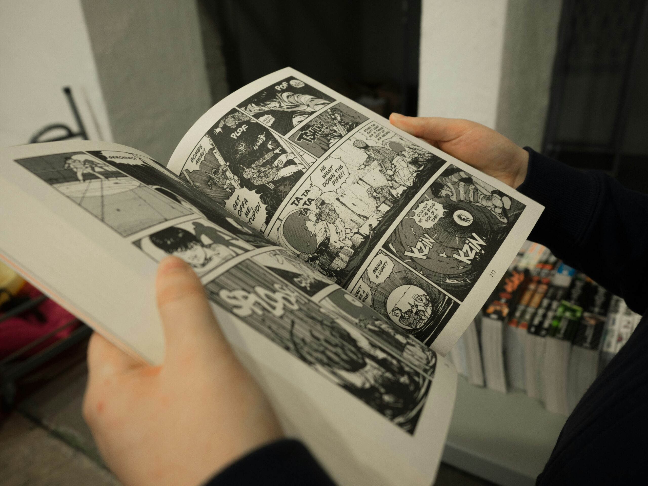 Une personne est en train de lire une bande dessinée de type comic book, avec des dessins dynamiques et des bulles de dialogue visibles.